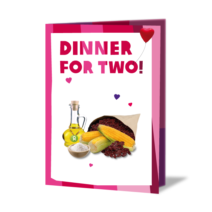 Geschenkkarte mit Aufschrift: Dinner for two! Darunter eine Flasche Öl, Bohnen, Mais und Schale Salz, umgeben von Herzen und ein Herzballon